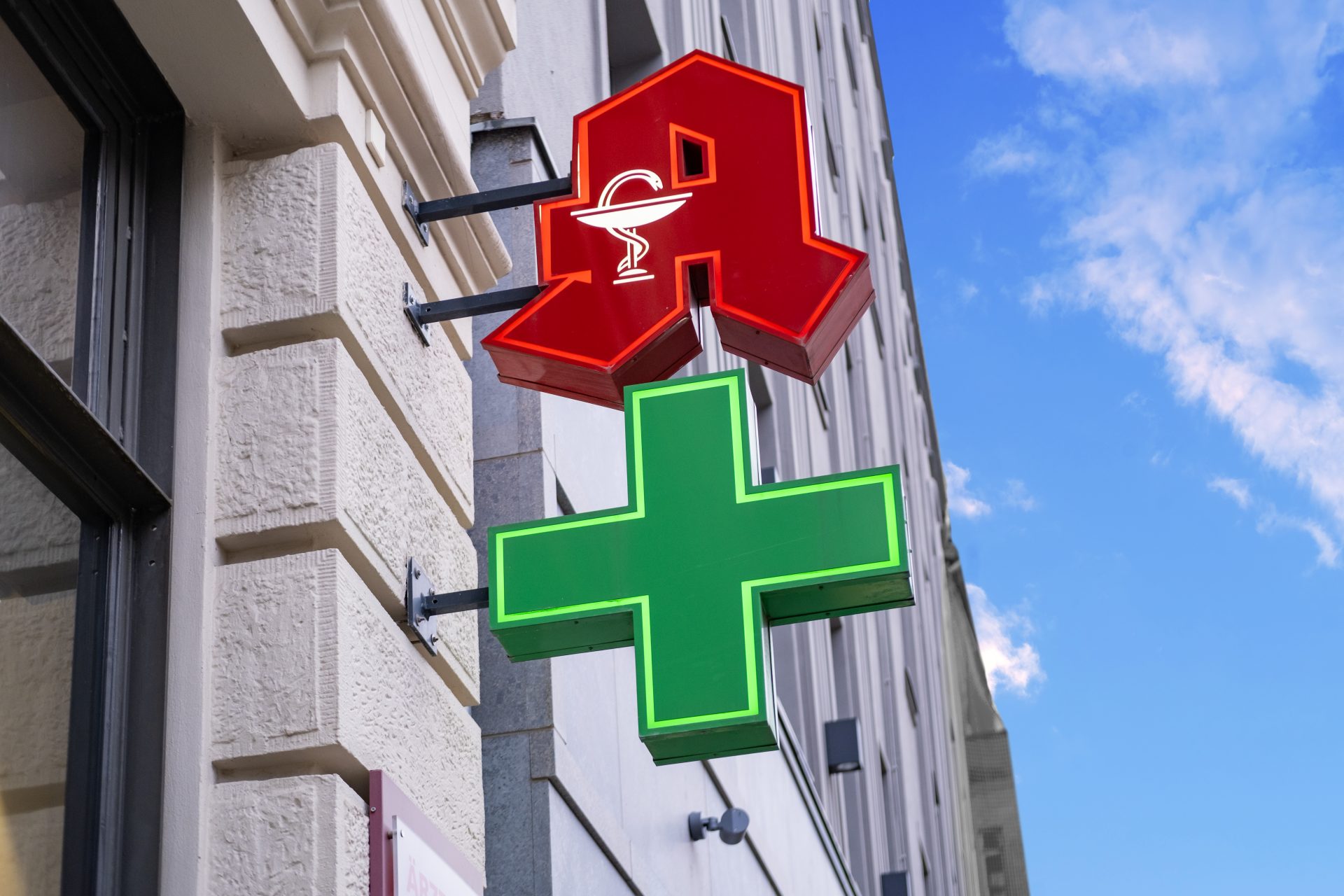 Apothekenschild mit rotem und grünem Kreuz
