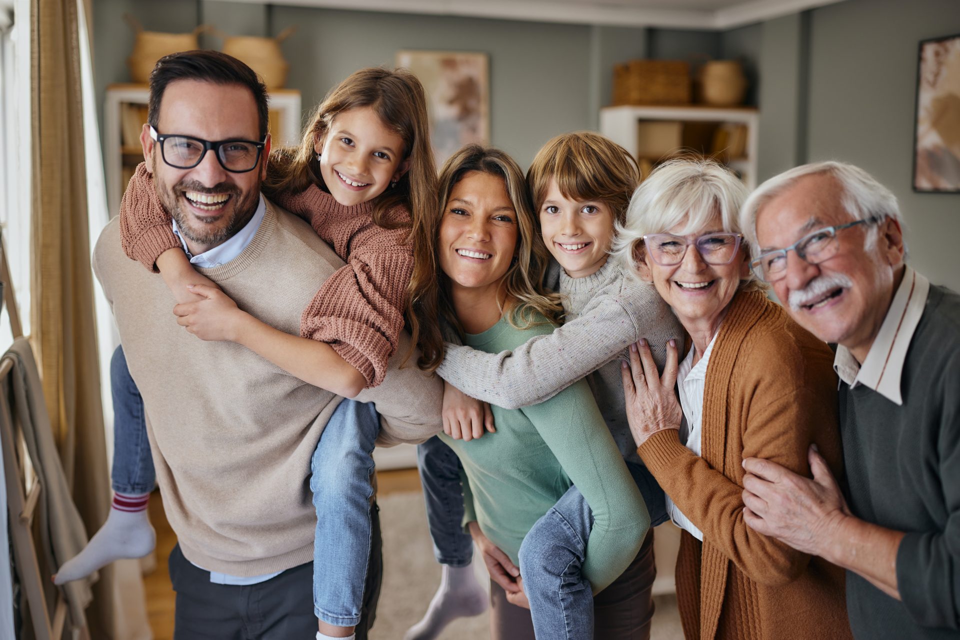 Eine vierköpfige Familie lächelt gemeinsam für ein Foto in ihrem gemütlichen Wohnzimmer
