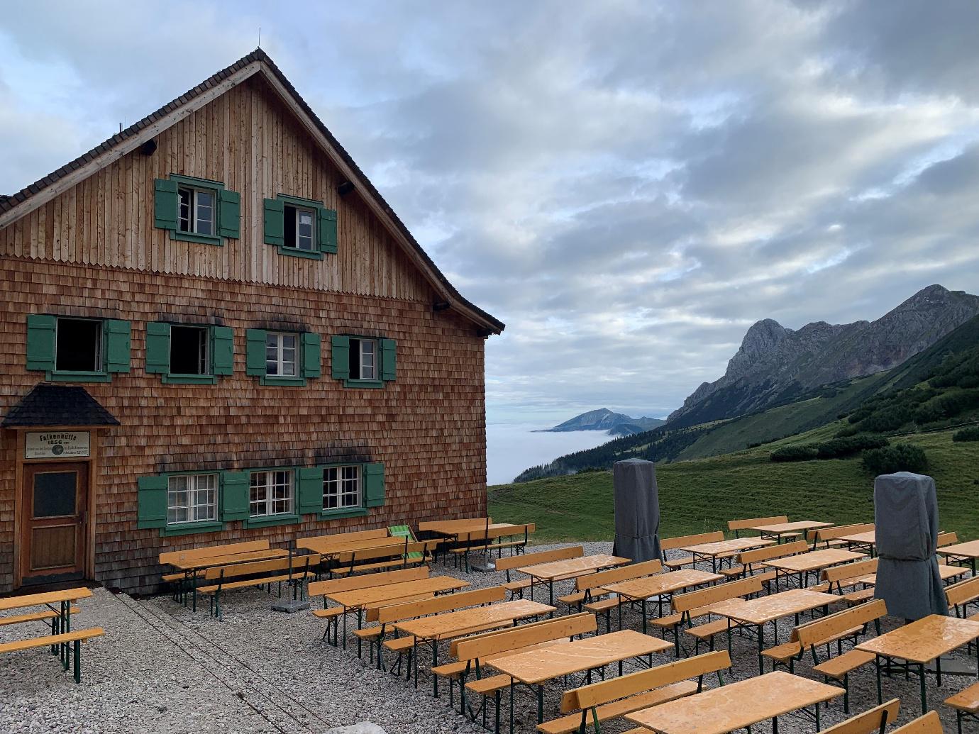 Berghütte mit Nebel und Tischen